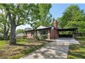 Quaint brick home featuring an attached carport and healthy landscaping at 264 Rockin Hill Dr, Marietta, GA 30060