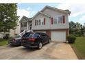 Two-story home features neutral siding, red shutters, brick accents, and a spacious driveway leading to a two-car garage at 116 Remington Place Blvd, Dallas, GA 30157