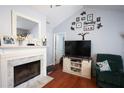 Cozy living room features a fireplace with marble surround and a vaulted ceiling, creating a warm and inviting space at 116 Remington Place Blvd, Dallas, GA 30157