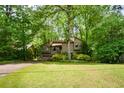View of home's exterior surrounded by lush greenery and mature trees at 2261 Ravenwood Trl, Marietta, GA 30066