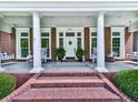 Charming front porch features brick steps, white columns, and porch swings, creating an inviting entrance to the home at 275 Frances Rd, Canton, GA 30114