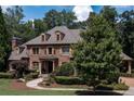 Charming brick home with dormer windows, complemented by mature trees and lush landscaping at 120 Kettering Trce, Tyrone, GA 30290