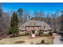 Stately brick home featuring lush landscaping, mature trees, and a circular driveway on a sprawling lot at 120 Kettering Trce, Tyrone, GA 30290
