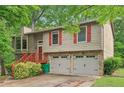 Inviting two-story home with red shutters, stone accents, and a two-car garage at 497 Fire Fly Dr, Tucker, GA 30084