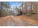 Exterior view showing a driveway leading to a house with an attached deck and a landscaped yard at 1645 Four Notch Rd, Carrollton, GA 30116