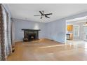 Cozy living room features a fireplace, ceiling fan, neutral paint, and wood floors at 1645 Four Notch Rd, Carrollton, GA 30116