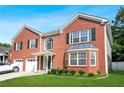 Two-story red brick home with an attached garage and a neatly kept front yard at 4125 Fallbrook Dr, Duluth, GA 30096