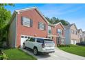 Two-story red brick home with an attached garage and a neatly kept lawn at 4125 Fallbrook Dr, Duluth, GA 30096