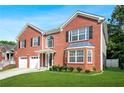 Beautiful brick home featuring a lush green lawn, mature landscaping, and a classic architectural design at 4125 Fallbrook Dr, Duluth, GA 30096