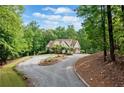 Exterior shot features winding driveway leading to the house surrounded by lush trees at 1825 Epperson Rd, Canton, GA 30115
