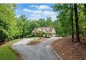 A beautiful view of this home from a distance, surrounded by mature trees at 1825 Epperson Rd, Canton, GA 30115