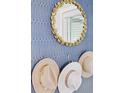 Close up of a blue accent wall with a decorative mirror and stylish hats at 407 Pratt Se Dr # 1101, Atlanta, GA 30315