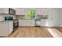The kitchen has white cabinets, a stainless dishwasher, a gas range and granite countertops at 70 Wheeler Lake Path, Dallas, GA 30157