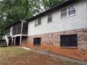 Back exterior featuring brick foundation, siding, screened porch, and surrounding landscape at 135 Golden Hills Dr, Woodstock, GA 30189