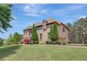 Elegant brick home with manicured lawn, sculpted shrubs, and verdant landscaping at 105 New Castle Ln, Tyrone, GA 30290