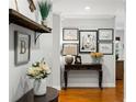 Light and airy foyer showcasing hardwood floors, decorative art, and a stylish console table with floral accents at 6800 Wright Rd, Atlanta, GA 30328