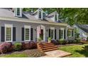 Well-maintained home exterior featuring gray siding, dormer windows, front lawn and mature shrubbery at 6800 Wright Rd, Atlanta, GA 30328