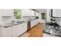 Modern kitchen featuring white cabinets, granite countertops, stainless steel appliances, and ample counter space at 6800 Wright Rd, Atlanta, GA 30328