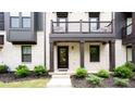 Close-up of a townhome entrance, highlighting the covered porch and neatly landscaped surroundings at 135 Climbing Ivy Cir, Fayetteville, GA 30214