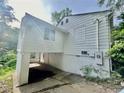 The exterior side of the house has a covered car port beneath an addition and adjacent greenery at 1440 Kenilworth Sw Dr, Atlanta, GA 30310