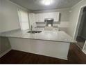 Bright kitchen features granite countertops, an island, and white cabinets for a modern look at 1440 Kenilworth Sw Dr, Atlanta, GA 30310