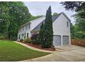 A two-story home with an attached two-car garage, well-manicured lawn, and mature landscaping at 1885 Dayron Trce, Marietta, GA 30062