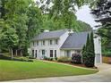 Two-story white brick home with a landscaped yard and an attached garage surrounded by mature trees at 1885 Dayron Trce, Marietta, GA 30062