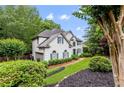 Traditional-style home showcases a manicured lawn, mature trees, and brick accents, exuding classic elegance at 220 Foxley Way, Roswell, GA 30075