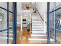 Inviting foyer features a staircase, hardwood floors, and an open view to the living room at 220 Foxley Way, Roswell, GA 30075