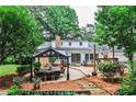 Outdoor living space offers dining area beneath a pergola and picturesque views of the serene backyard at 2244 Deer Ridge Dr, Tucker, GA 30087