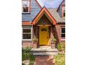 Close-up of a bright yellow front door with brick surround and stone steps at 588 Oakdale Ne Rd, Atlanta, GA 30307