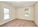 Bright bedroom with carpet flooring and two windows offering natural light at 6316 Rockland Rd, Lithonia, GA 30038