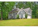 Stylish two-story house with a lush green lawn, mature trees, and a side-entry garage at 1256 Spring Park Sw Dr, Atlanta, GA 30311