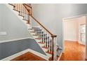 Elegant staircase with hardwood steps, white risers, and a wooden handrail, leading to the upper level at 1256 Spring Park Sw Dr, Atlanta, GA 30311