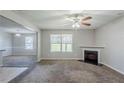 Cozy living room featuring fireplace and carpeted floors, open to adjacent room at 1436 Arbor Place Dr, Morrow, GA 30260
