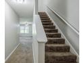 Carpeted staircase with white handrail leads to upper level with view of living area at 1436 Arbor Place Dr, Morrow, GA 30260