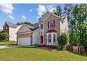 Charming two-story home with manicured lawn, brick accents, and a bright red front door at 1224 Everwood Sw Dr, Marietta, GA 30008
