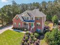 Two-story brick home with green shutters, a welcoming front porch, and lush landscaping at 1829 Alcovy Shoals Blf, Lawrenceville, GA 30045