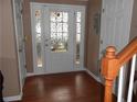 Welcoming foyer featuring hardwood floors, a decorative front door, and staircase with wooden banister at 2019 Briar Creek Ne Ct, Conyers, GA 30012