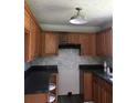 Traditional kitchen with black countertops, tile backsplash and light wood cabinets at 75 Oak Hill Dr, Covington, GA 30016