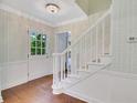 Inviting foyer with hardwood floors, wainscoting, wallpaper, and a staircase with white banister at 770 Wellesley Nw Dr, Atlanta, GA 30305
