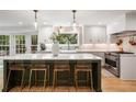 Bright kitchen features modern white cabinets, stainless appliances, and a large island with seating at 1435 Withmere Ln, Atlanta, GA 30338
