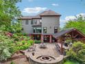 Backyard with a stone patio, built-in barbecue area, fire pit, and lush landscaping at 3282 Green Farm Trl, Dacula, GA 30019