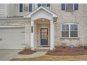 Close up showcasing the front entryway, featuring brick accents, dark blue door and manicured landscape at 3652 Silvery Way, Powder Springs, GA 30127