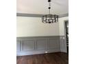 Elegant dining room with decorative molding, modern chandelier, and hardwood floors at 5907 Sw Bunting Ln, Atlanta, GA 30331