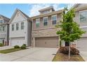 Attractive townhome showcases a two-car garage, a mix of brick and siding, and front yard landscaping at 1227 Herty Dr, Marietta, GA 30062