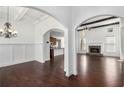 Open-concept living room featuring a stone fireplace, hardwood floors, and elegant archways at 448 Hanover Drive, Villa Rica, GA 30180