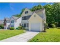 Two-story light yellow home with an attached one-car garage, well kept lawn, and a concrete driveway at 4812 Browns Mill Ferry Rd, Lithonia, GA 30038