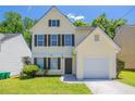Charming light yellow home with brown shutters and a well-manicured lawn, plus an attached one-car garage at 4812 Browns Mill Ferry Rd, Lithonia, GA 30038