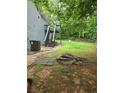 Spacious backyard featuring a fire pit, deck with stairs, and mature trees offering ample shade at 144 Boones Ridge Se Pkwy, Acworth, GA 30102